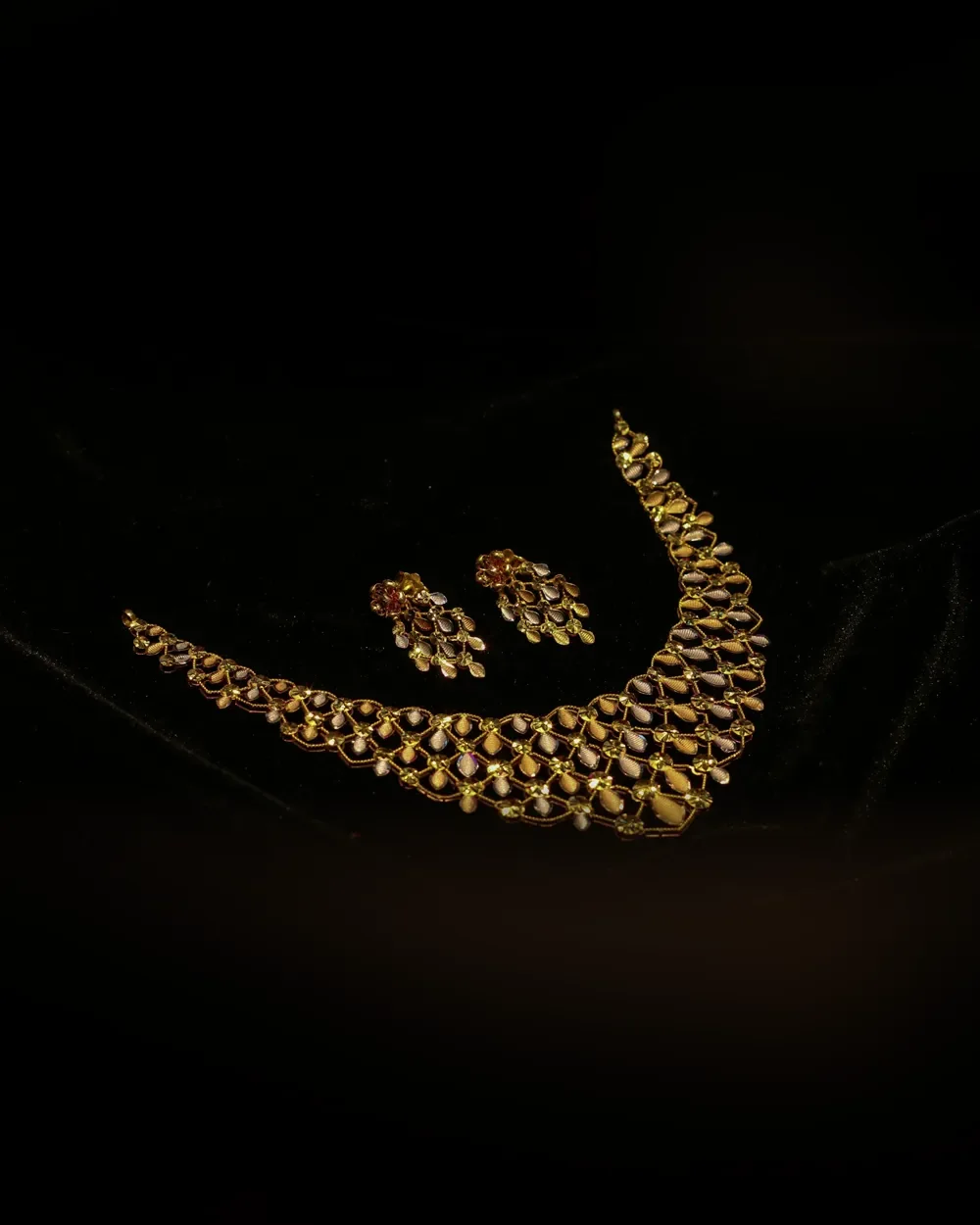 Gold necklace with matching earrings on black velvet